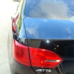 Before and after photographs of a damaged black Volkswagon Jetta that was repaired by Elite Paint & Body Shop in West Palm Beach, Florida.
